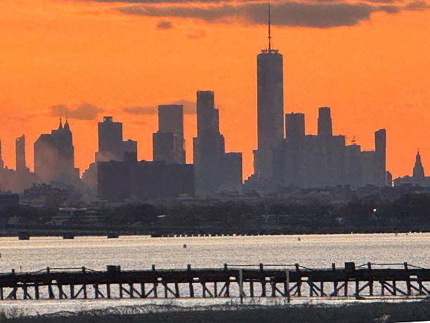 sillouette of new york city skyline back lit with orange sunset
