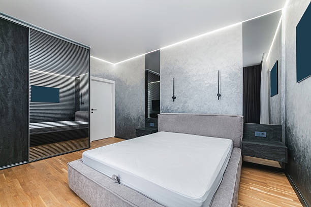 istock This spacious bedroom showcases a minimalistic design featuring a gray bed frame and polished wooden floors 2227124145