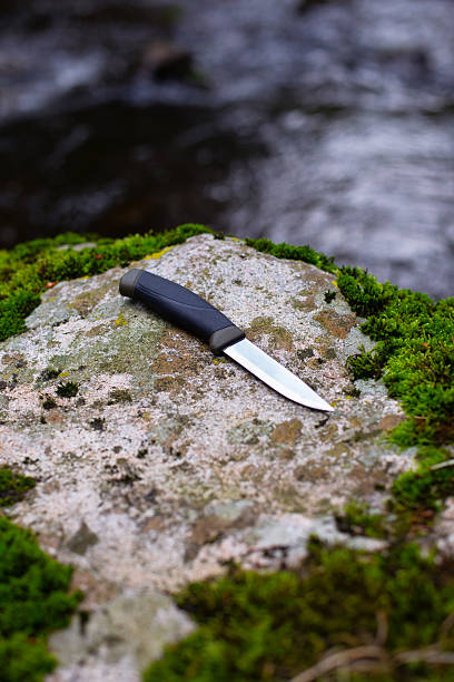 istock camping knife on a stone near a river 2227127731
