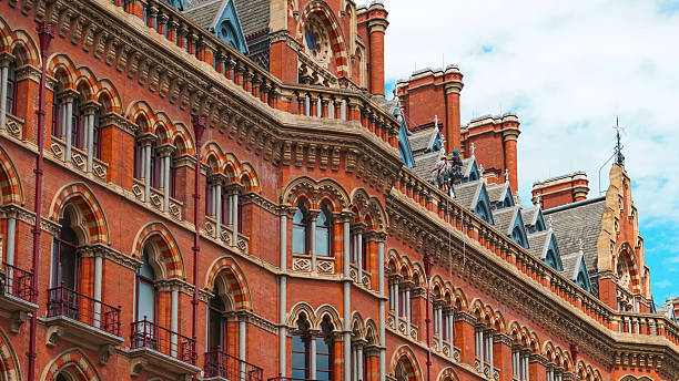 istock Victorian Gothic architecture with red bricks and clock tower in London city. 2227127751