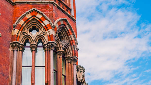 istock Victorian Gothic architecture with red bricks and clock tower in London city. 2227127936