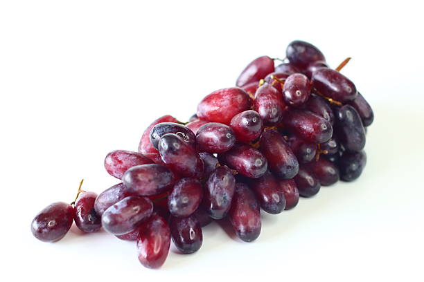 Fresh black seedless grapes, oval and elongated variety, arranged on a white background. Juicy, sweet, mildly tart flavor, perfect for healthy eating, nutrition, fruit photography, blogs and stock use