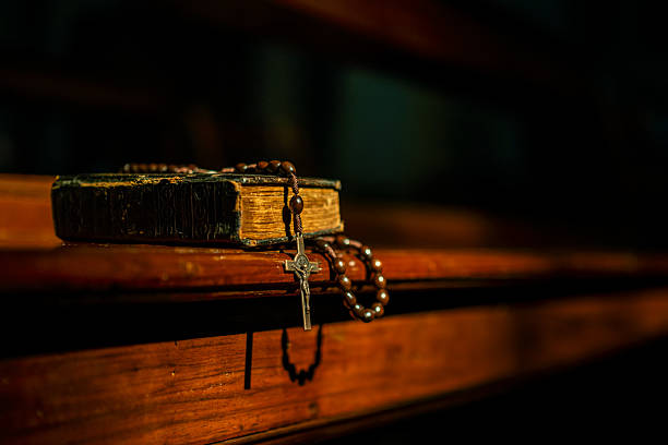 The Old Bible on a wooden church pew, illuminated by warm, soft lighting.