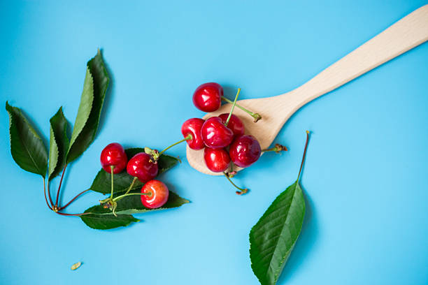Ripe cherries isolated on a blue background.