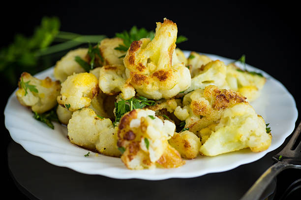 Vegetable dish of fried cabbage with aromatic spices on a black background.