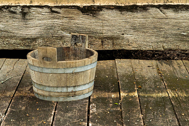 An old wooden bucket with handles for pole