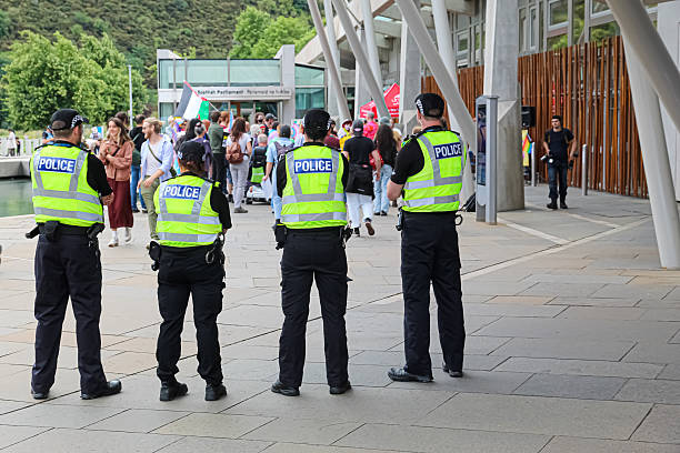 Edinburgh, Scotland - 26 July 2025 Four Police Scotland officers standing by an anti hate and pro LGBTQ demonstration outside the Scottish parliament in Edinburgh