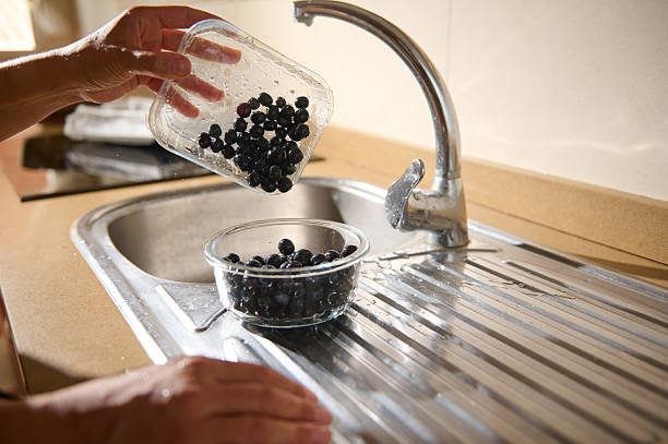 istock Person Rinsing Fresh Blueberries Under a Tap in a Kitchen Sink 2227152511
