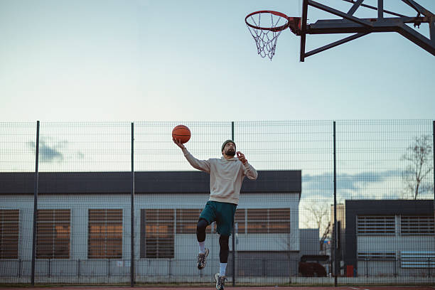 istock Young Basketball Player Practicing on Urban Court at Sunset 2227153314