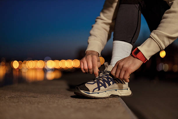 istock Man Tying Shoe Laces Preparing for Night Run 2227153377