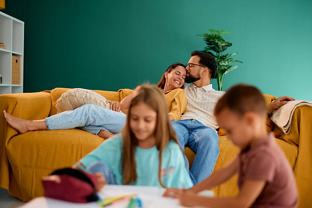 istock Parents relaxing on sofa while children are drawing at home 2227153613