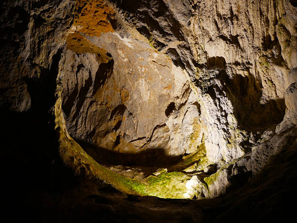 natural hole in a stone wall in a cave illuminated by artificial light