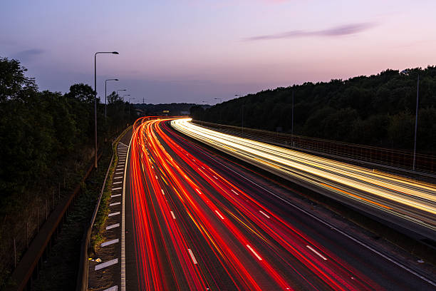 istock Light trails illuminating highway at dusk with purple sky 2227157124