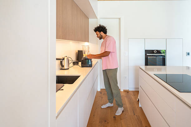 istock Middle Eastern Man Blending Blueberry Smoothie in Modern Kitchen 2227160455