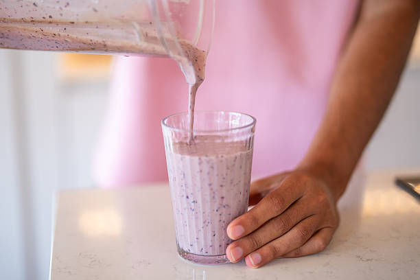 istock Middle Eastern Man Pouring Fresh Blueberry Smoothie in Modern Home Kitchen 2227160463