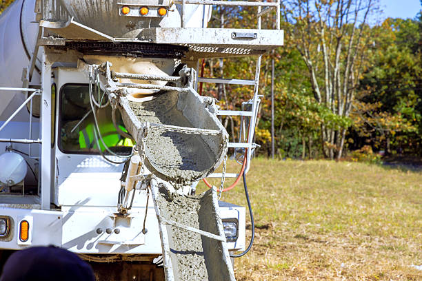 Concrete truck is discharging fresh concrete at construction site amid during works day