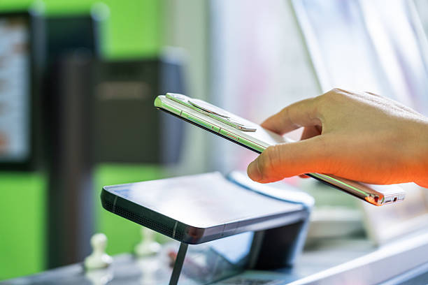istock Hand holding mobile phone for contactless payment at a payment terminal 2227169168