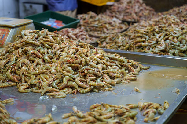 Large quantity of fresh shrimp displayed for sale at a wet market seafood stall.