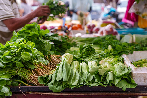 Fresh Green Leafy Vegetables at a Bustling Market Stall
