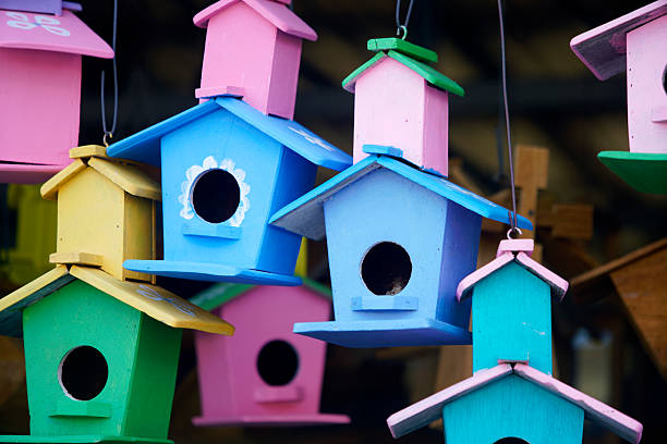 istock Colorful Birdhouses Hanging in a Rustic Wooden Setting 2227178759