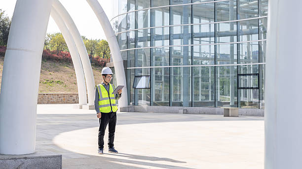 istock Construction worker in safety vest using tablet outdoors 2227180146