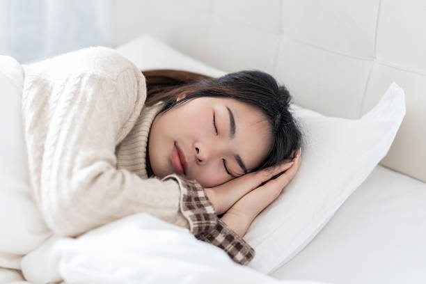 istock A woman sleeping peacefully in a cozy bedroom 2227182040