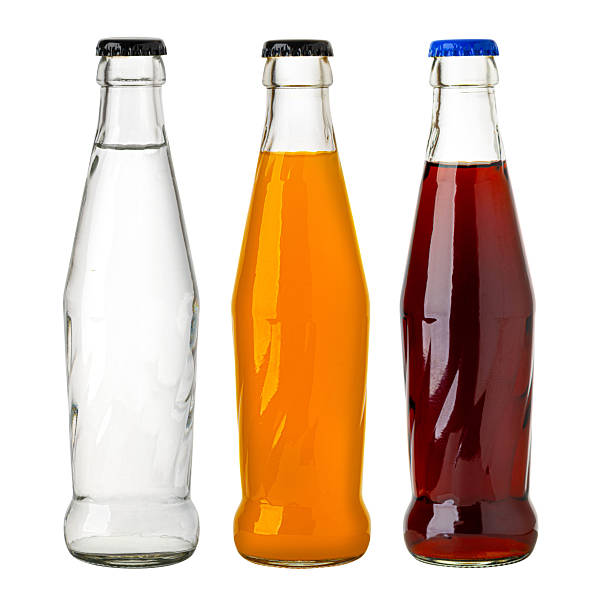 Refreshing soda drinks in glass bottles featuring a variety of vibrant colors, isolated on white