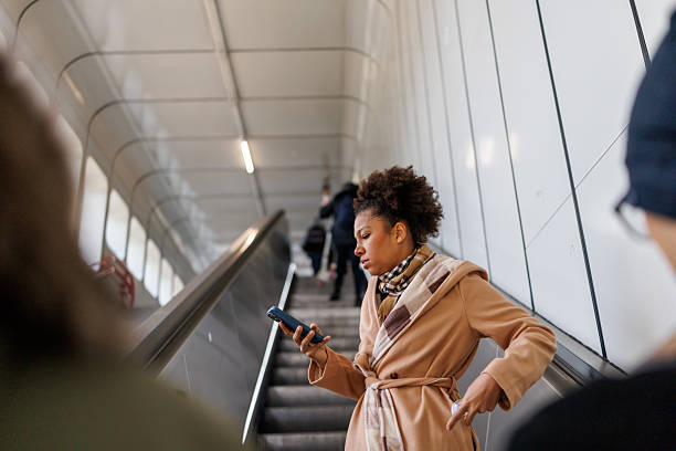 istock Beautiful multiracial woman using phone on subway escalator 2227196040
