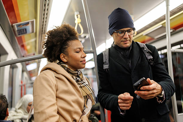 istock Multiracial couple of tourists using mobile phone while traveling by subway train 2227196670
