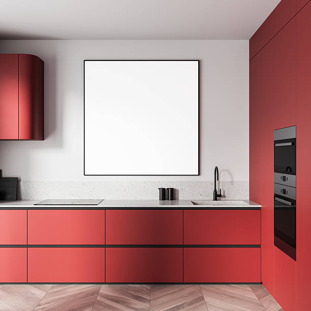 Contemporary red kitchen interior with clean layout, featuring blank square poster mockup on white wall above counter. 3D Rendering