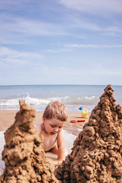 istock Girl building a sandcastle on the beach 2227201018