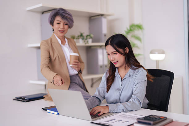istock Asian adult businesswomen actively collaborating on project data using laptop computer in modern office setting for effective strategy implementation 2227202478