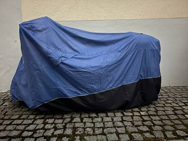 istock Blue and black motorcycle cover is draped over a motorcycle 2227203894