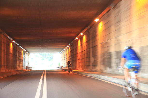 istock Man in a blue shirt is riding a bicycle down a road 2227204547