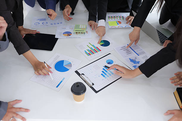 istock Group of business hands analyzing business graph on a laptop computer at office desk. 2227205519