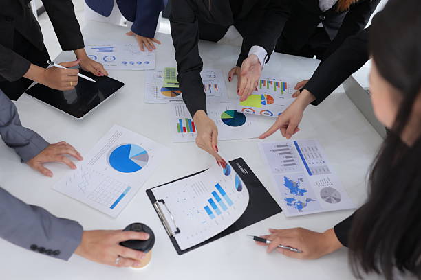 istock Group of business hands analyzing business graph on a laptop computer at office desk. 2227205524