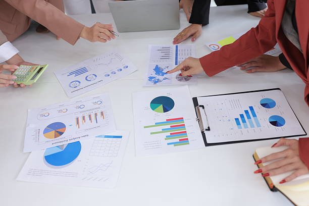 istock Group of business hands analyzing business graph on a laptop computer at office desk. 2227205569