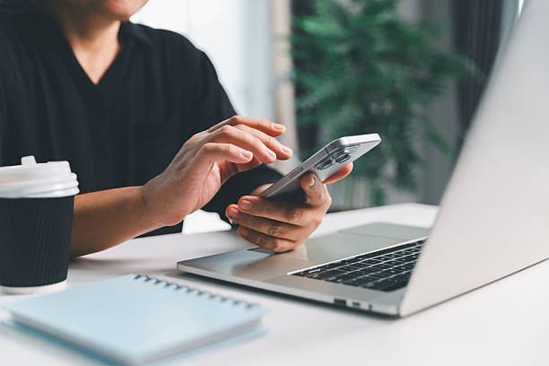 istock Close-up scene, a female seated at a table holds a smartphone, spending time on modern e-date services and social media through a mobile app, illustrating the wireless concept of digital usage. 2227211126