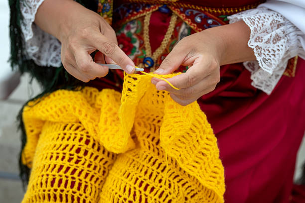 Female hands are knitting with yellowe yarn