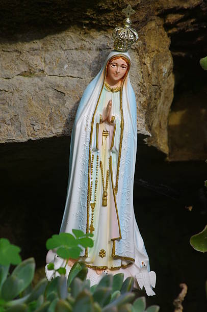 istock Statue of Mary is sitting on a rock 2227213206