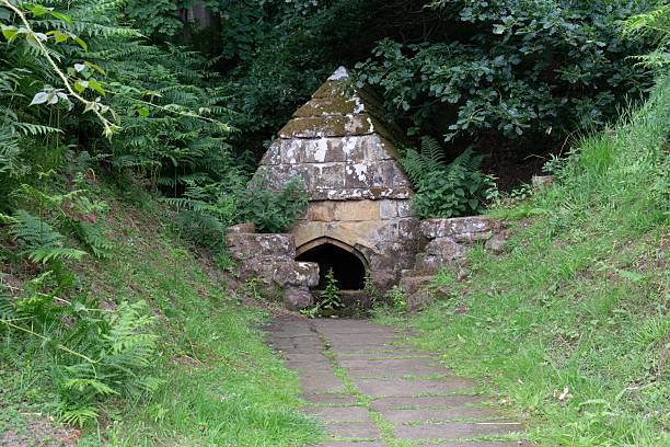 istock A stone structure, likely a spring or fountain, has a pyramid-shaped top, and an arched opening. 2227215171