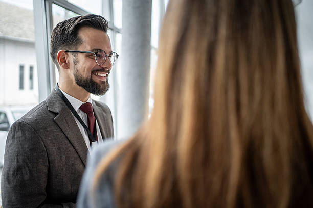 istock Businessman smiling and talking with colleagues in office 2227215638