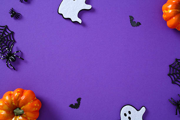 istock Halloween border composition on purple background with ghosts, bats, pumpkins, spiders, and webs. 2227218097