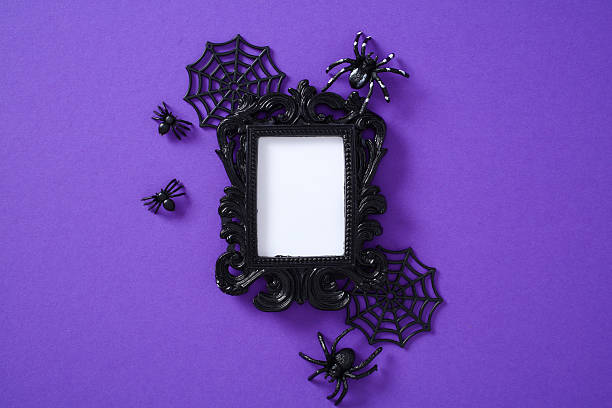istock Halloween composition with ornate black frame, plastic spiders, and webs on vibrant purple background 2227218123