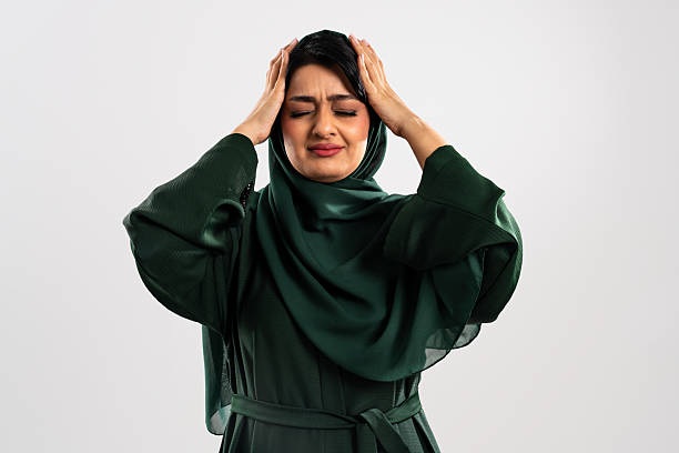 istock Muslim woman suffering from a headache touching her head 2227222877