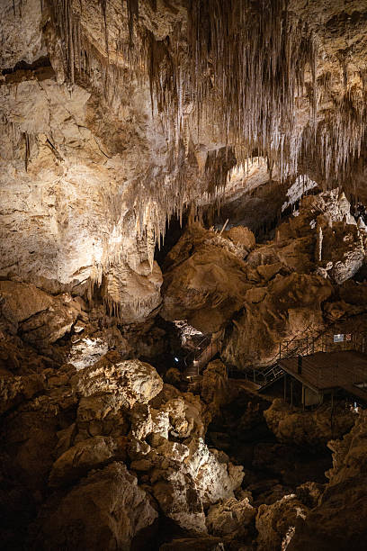 istock Stalactites and Rocky Formations Inside an Illuminated Underground Cave 2227222901