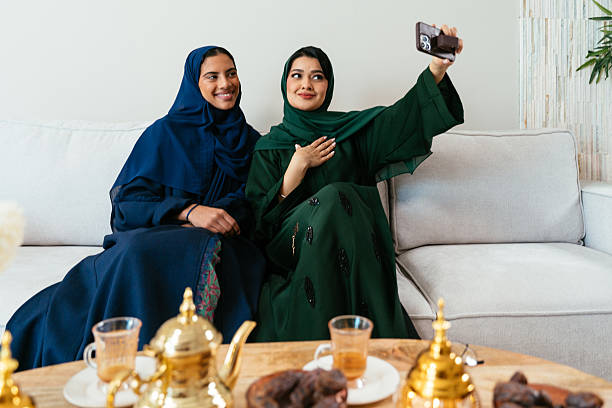 istock Emirati women taking selfie on sofa at home 2227224022