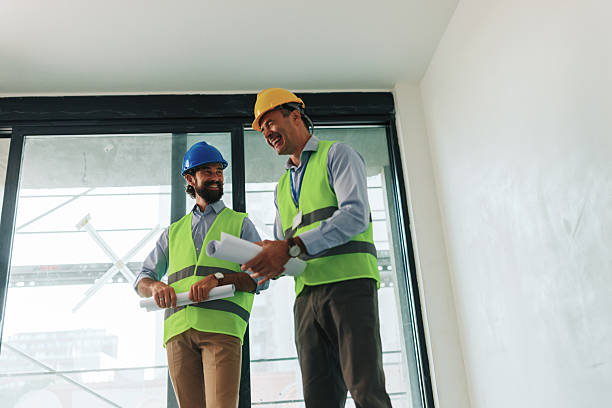 istock Two architects discussing building plans inside unfinished building 2227226679