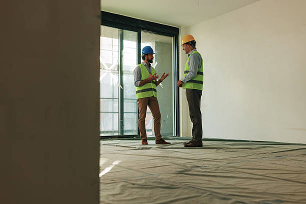istock Two architects discussing building plans in a new apartment 2227226789
