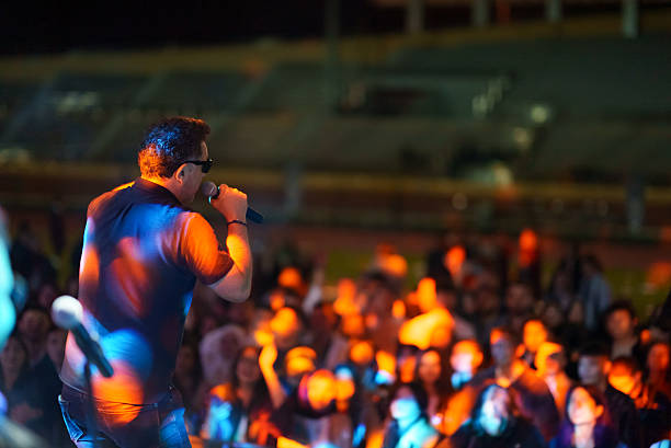 istock Rock Band Vocal Singing Live on Stage with Vibrant Lighting 2227229700